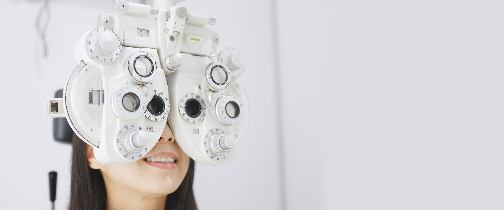 Hill Vision Services Woman getting her eyes checked with an eye exam machine